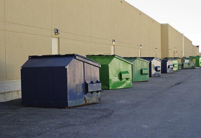 tilted front-load dumpsters being emptied by waste management workers in Addison